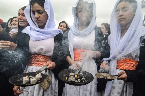 Iraqi Yazidi women take part in a ceremony during the exhumation of a mass-grave of hundreds of Yazi