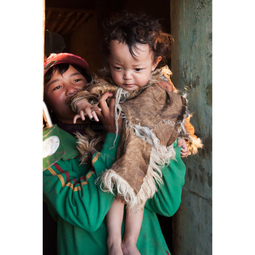 Sisters play in the first warming rays of the sunshine on the Tibetan plateau while the family of 10