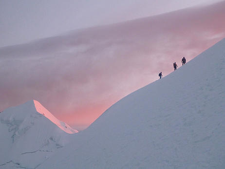 house-under-a-rock: Climbers reaching the summital ridge of Illimani mountain early in the morning, 