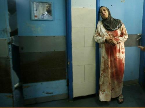 androphilia: A Palestinian woman covered in relatives blood, cries at a Gaza hospital. Helplessness 