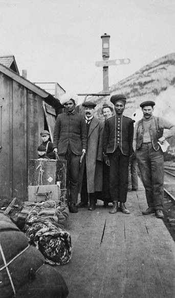 Group, including East Indians, on platform of C.P.R. (Canadian Pacific Railway) Station, Frank, Alta