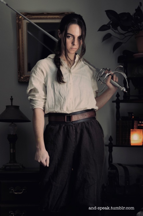 and-speak:

they/themgender of the day: pirate[image description: four photos of op, a white person with long brown hair worn in a braid, wearing an ivory colored linen button down shirt tucked into brown linen pants, and a wide leather belt. they wield a swept hilt rapier. end image description.] 