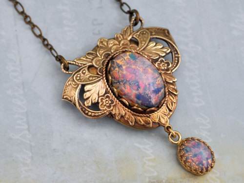 wickedclothes:  Victorian Pink Fire Opal Locket This brass locket features an ornate, Victorian style pattern. In the center of the locket rests a pink fire opal gem, and a pink fire opal also dangles from the bottom. Hung on an 18” chain. Sold on Etsy.