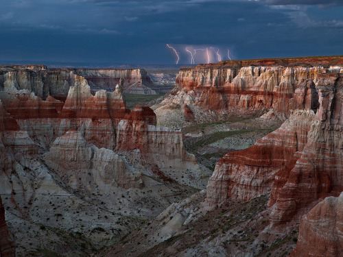 A distant storm passes by Coal Mine Canyon on the Navajo Indian Reservation in northern Arizona, USA