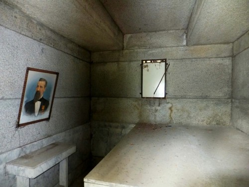 Old mausoleum interior with portrait.