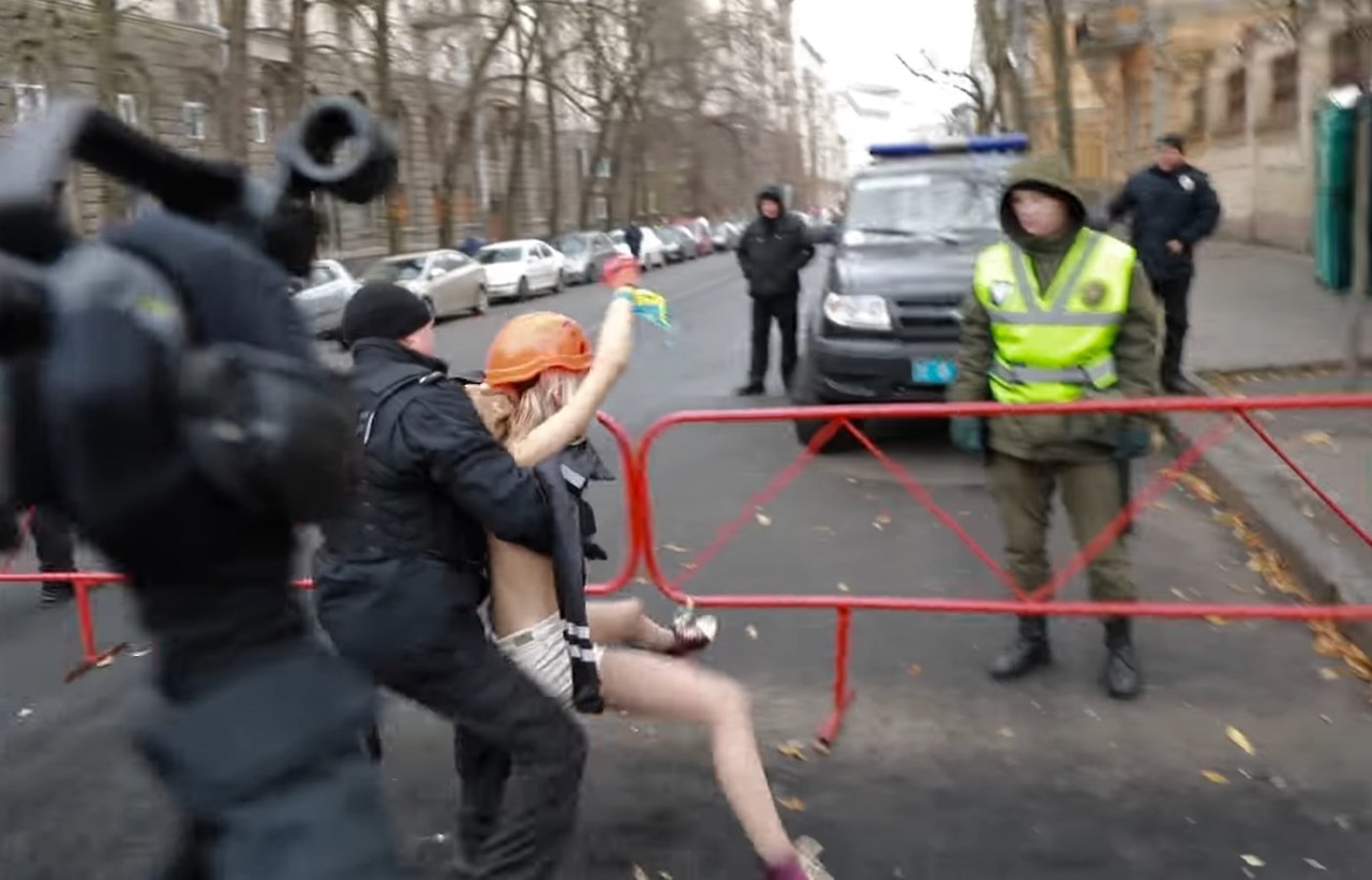 PROTESTA EN KIEV. Policías detienen a activistas en topless del grupo de derechos de las mujeres Femen durante una protesta contra el presidente ucraniano Poroshenko en Kiev, Ucrania, el cuarto aniversario de la Revolución de la Dignidad....