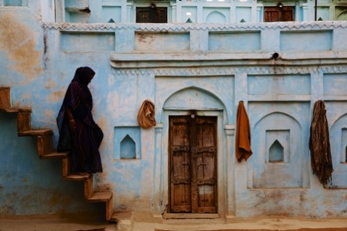 unrar:A woman walks down steps wearing a traditional Indian sari, Orchha, Madhya Pradesh, India, Gia