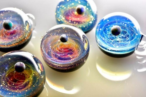 zombies-with-radios:  http://plusalpha-glass.com/index.html  Artist Satoshi Tomizu creates small glass spheres that appear to be miniature solar systems or galaxies, in which planets made of opal are circling into spirals of colored glass and gold flakes.