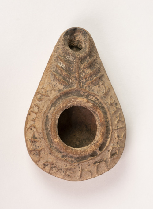The relief design on the nozzle of this oil lamp may represent a seven-branched candlestick, and the