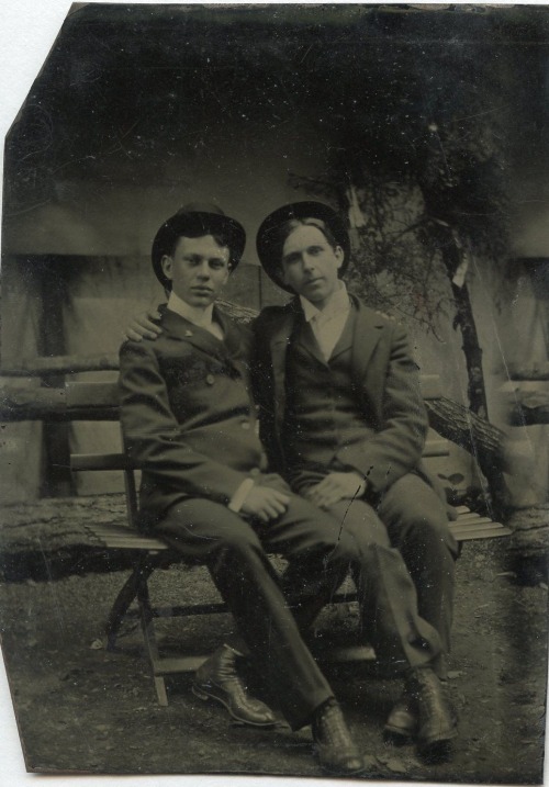 A tender image of deep affection; two handsome young gents share a bench, and an obvious close compa