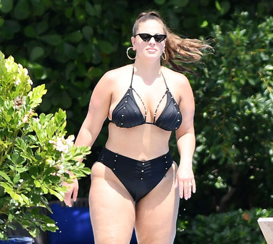 Ashley Graham Sunbathing In Black Bikini Plus sized model Ashley Graham has problems finding bathing suits that fit her large frame. She is now wearing a swimsuit that is barely covering her ass and we can see her buttcheeks hanging out while she is