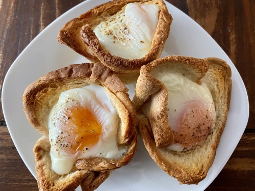 Toast flattened with a baking roll, in a muffin tin, smeared with butter and filled with a few cubes