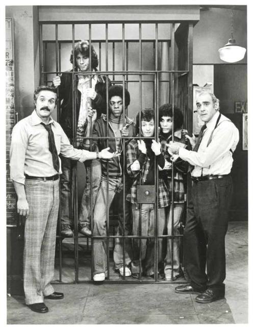 broadcastarchive-umd:  Publicity photo for two ABC sitcoms: Barney Miller (1975-1982) and Welcome Back, Kotter (1975-1979). Both aired on Thursday nights. From Barney Miller, on the far left is Hal Linden and on the far right, Abe Vigoda. Inside the cell
