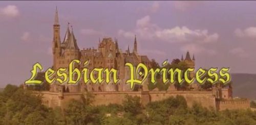 The picture features a large, stone castle situated on a hill, surrounded by lush green trees. The castle is multi-towered and appears ancient and grand with a fortified wall surrounding it. The sky is mostly cloudy, giving a somewhat somber, yet romantic, atmosphere. The overall mood is mysterious and intriguing, perhaps suggestive of a fairy tale or historical drama. The title "Lesbian Princess" is written in a stylized, old-English font in yellow against the image of the castle.