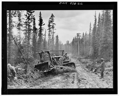 A Caterpillar tractor with grader widening the roadway of the AlaskaHighway (1942).