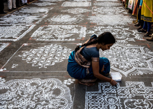 Woman making kolam at southern India festival