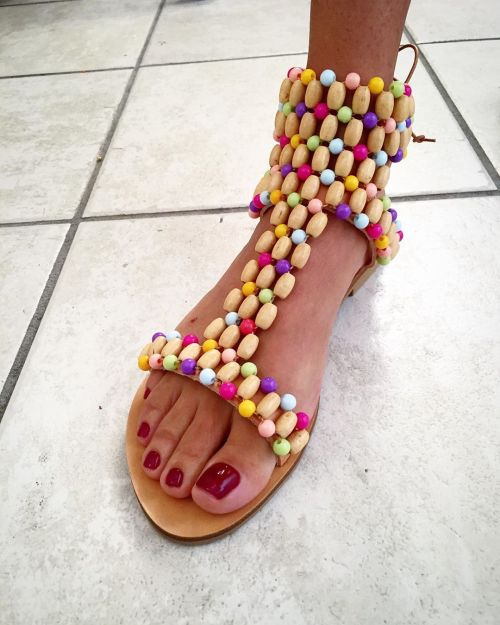 Crazy looking beaded sandals on pretty feet.