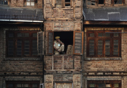yahoonewsphotos:  Photos of the day - July 13, 2014 An Indian policeman keeps a vigil through the window of a residential building next to the Martyrs’ graveyard, during Martyrs’ Day in Srinagar, Bryan Schouten, left, and Scott Deroue, right, both