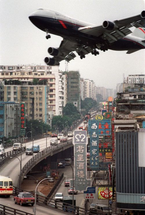 British Airways B747 banking over the rooftops of Kowloon to land at Kai Tak, Hong Kong, 1990. Photo