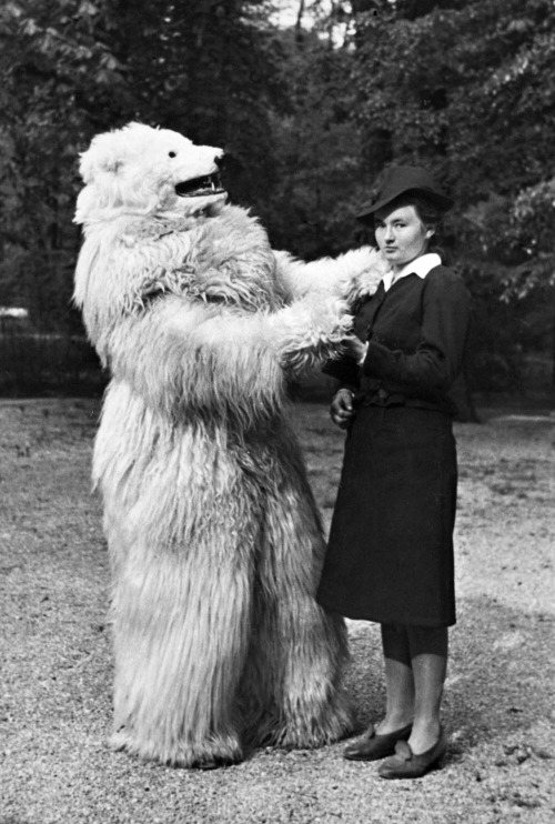 Unhappy woman dances with person in a polar bear costume, Germany, 1935.