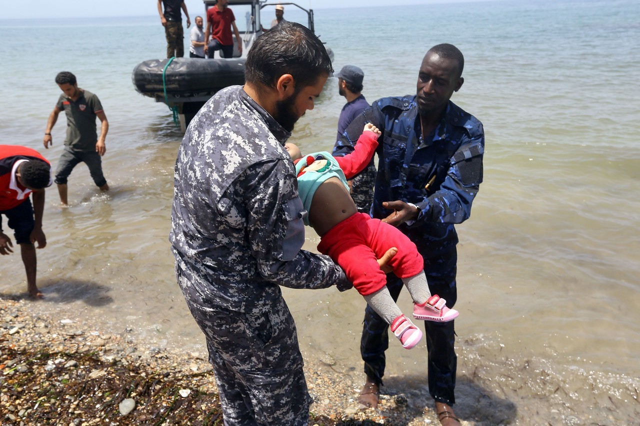 NAUFRAGIO. Miembros de las fuerzas de seguridad libias transportan los cadáveres de bebés mientras los migrantes que sobrevivieron al hundimiento de un bote inflable frente a las costas de Libia son llevados a tierra en al-Hmidiya, al este de la...