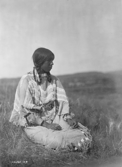 thebigkelu:Piegan woman seated on ground in open field. - Curtis - 1910