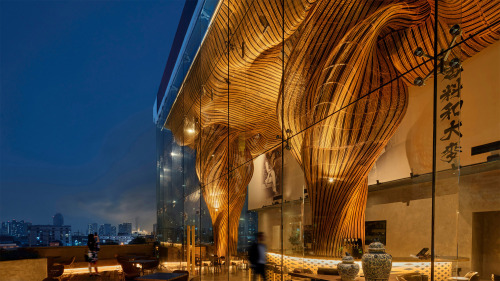 itscolossal: Swirling Plumes of Black-and-Gold Rattan Fill the Ceiling of a Bangkok Lounge