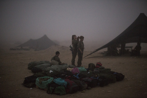 Female soldiers of the Bardales Battalion fix their hair as they get ready on an early foggy morning