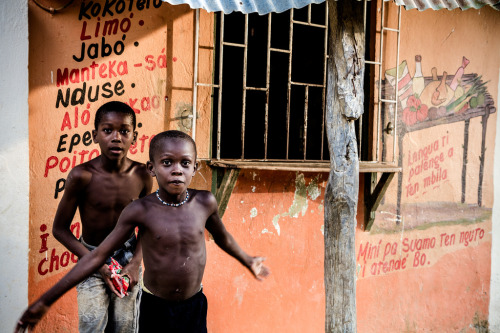 Colombian children play in front of a grocery store advertising products in PalenqueroPalenquero is 