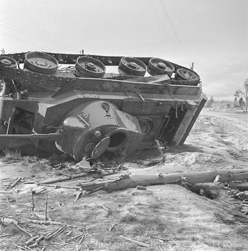 historicaltimes:Continuation war destroyed tank in Salla. Wooden cross marks the grave of its driver