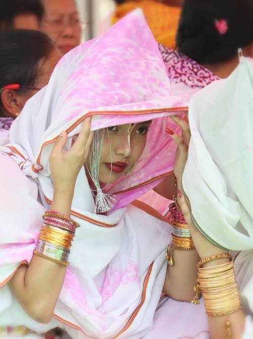 Beautiful veiled woman protecting themselves from the colored powders, Holi Festival at Radha Govind