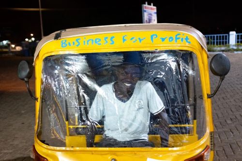 A young driver poses in his auto-rickshaw, a cheaper mode of transport booming in communities lackin