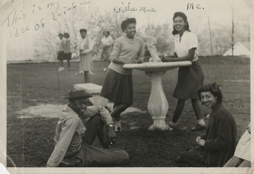 Four people next to a bird bathBlack and white photograph of three women and one man arranged around