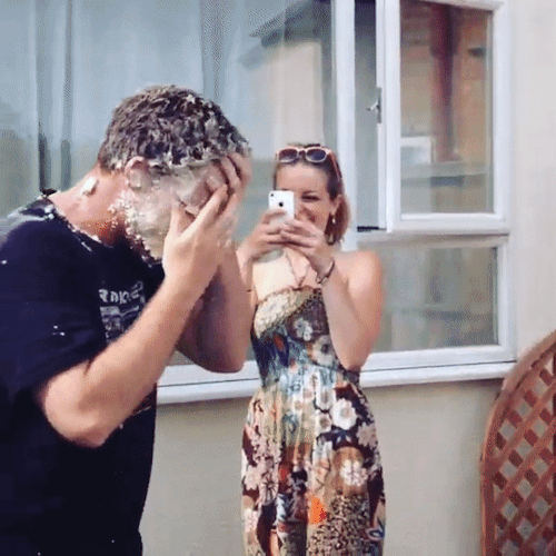 Tattooed guy gives his mate a pie in the face