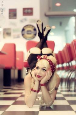 rockabillychickus:  A little bit saucy for my blog but what the hell. Im Jealous of this look as shes so fit with a great booty in a cafe where i would love to be. Its like shes looking at her bloke playing nintendo video games and proud of him.Sexy