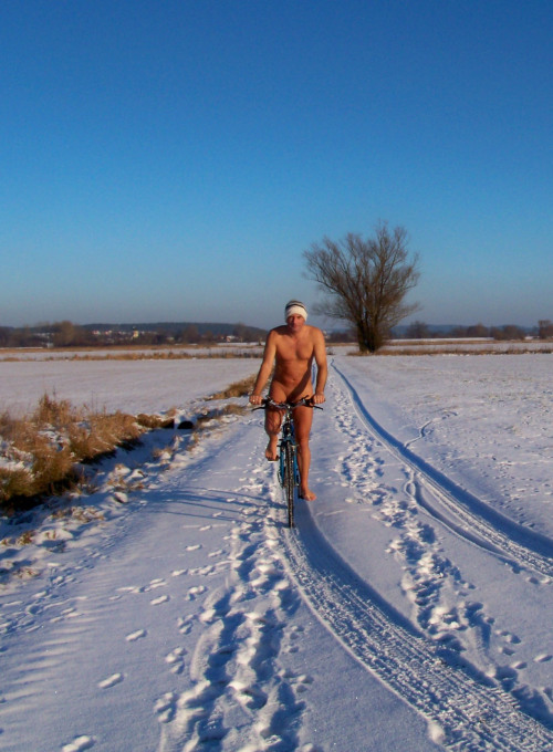 Biking cross a snowy field.