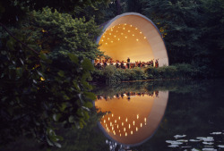 unrar:  Orchestra plays beneath stars in orchestra shell reflected on lake, London, James P. Blair.