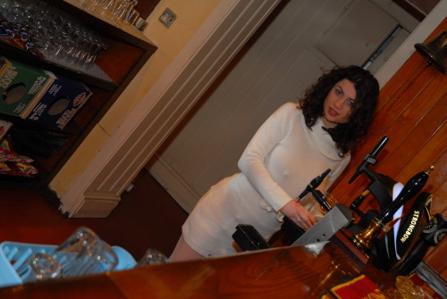 stockingsandbumps: Sexy barmaid braless and showing suspender bumps under her tight dress wearing fi