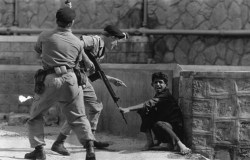 An Aden civilian crouching in terror as British soldiers threaten him during Arabian demonstrations in Crater. (Photo by Express Newspapers/Getty Images). 1967