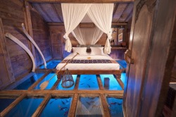 sixpenceee:  This bedroom may claim to be the world’s most stunning room. It is equipped with a glass floor that allows you to enjoy the incredible beauty of the tropical underwater world. The bedroom is located in the house “Udang House” (or Shrimp