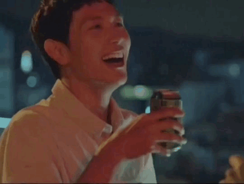 Jongwoo laughing, holding the can to his chest.