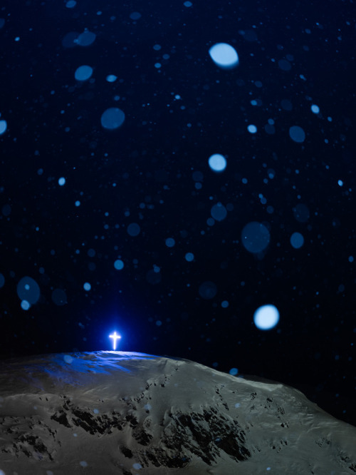 The cross shining brightly over the northern community of Kangiqsujuaq on a snowy night.Photographed