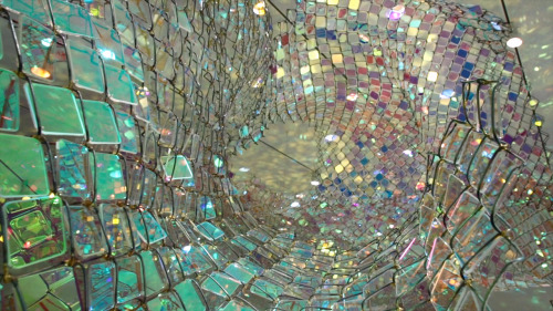 Soo Sunny Park (b. Seoul, Korea) - Unwoven Light at Rice University’s Rice Gallery in Houston, Texas. Composed of 37 individual sculptural units, the installation uses iridescent plexi-glass embedded in pieces of a chain link fence to cast shimmering,