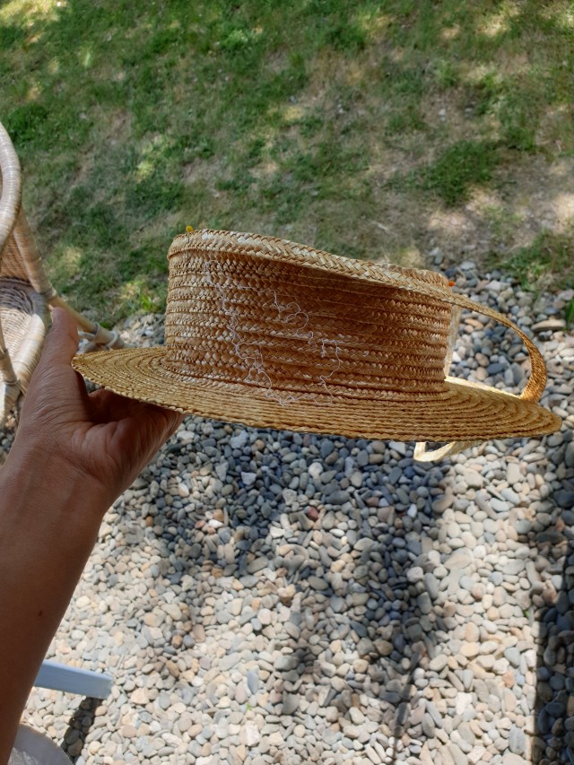 the hat without crown with a straw braid sticking out of it