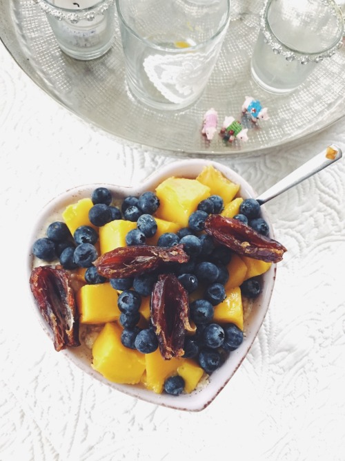 a bowl of joy vanilla-mango-date chunks-oatmeal topped with more mango, dates and blueberries. delic