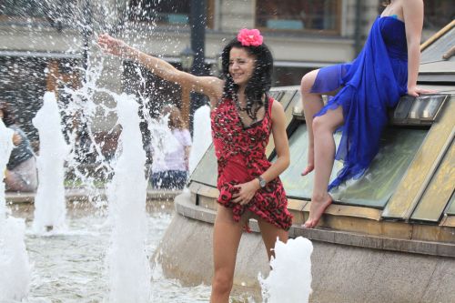 Woman playing in a fountain in natural reinforced pantyhose.Woman in pantyhose