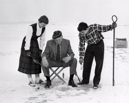 University President  E.B Fred goes ice fishing with Ruth Pommerening and Aristotle Alexander, Madis