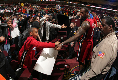 nba:  LeBron James of the Miami Heat greets a young fan during the game against the Cleveland Cavaliers at The Quicken Loans Arena on March 18, 2014 in Cleveland, Ohio.  (Photo by Joe Murphy/NBAE via Getty Images)