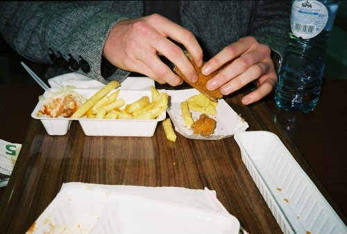 De amerikaan die zijn eerste frietje speciaal met een kroket eet. Bij de smerigste snackbar in Amste