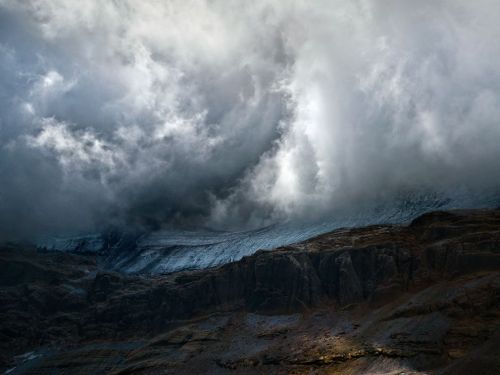 nationalgeographicmagazine:  Monte Perdido, Spain Photograph by Maxime Daviron, Your ShotThe north face of Monte Perdido in the Spanish Pyrenees. The mountain was masked by the clouds for three days, revealing the glacier occasionally. It was really cold